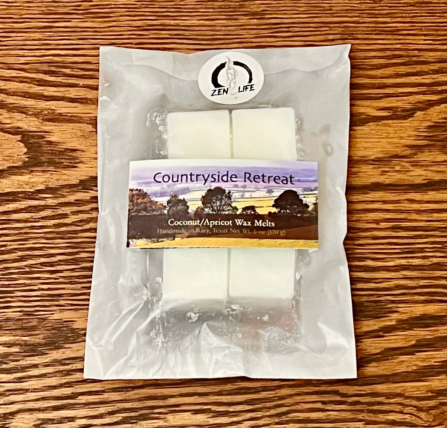 Wax melts for the Countryside Retreat scent on a wooden surface. Each bag contains six 1 oz melts.